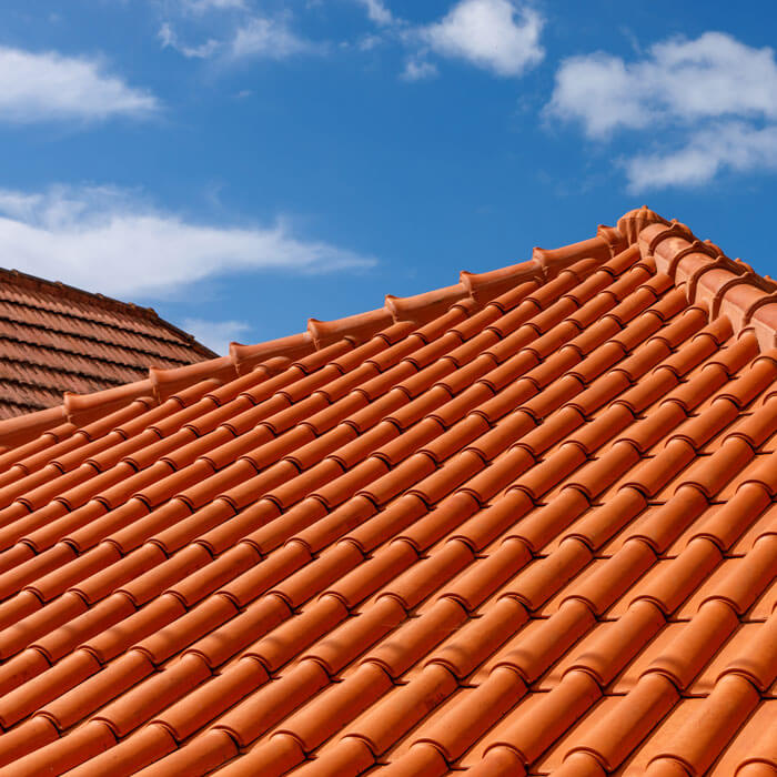 Red clay roof tiles under blue sky